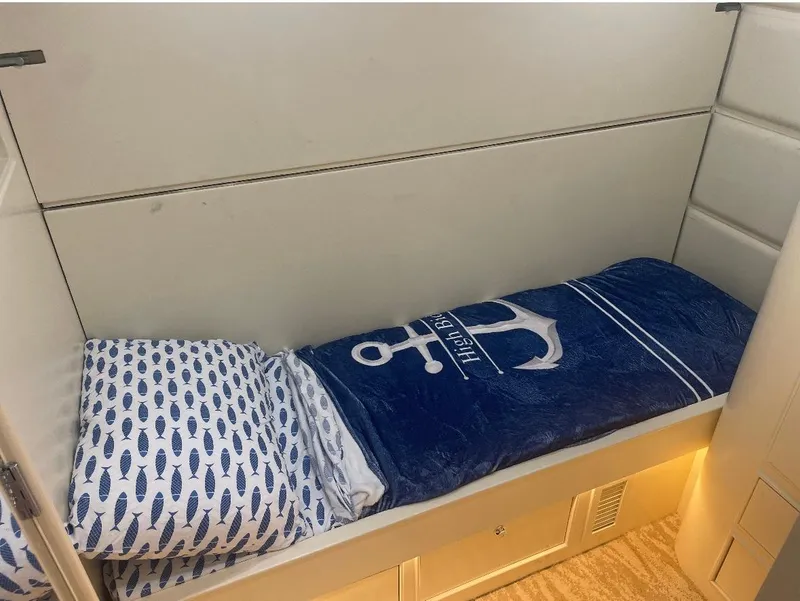 Slide: The Image of Cozy cabin bed in 1990 Striker Sportfish boat with nautical-themed bedding. - 16