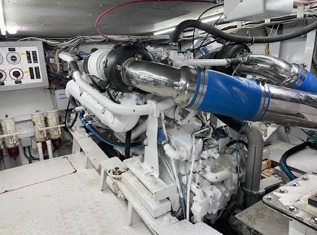Slide: The Image of Engine room of a 1990 Striker Sportfish boat, showcasing complex machinery and piping. - 22