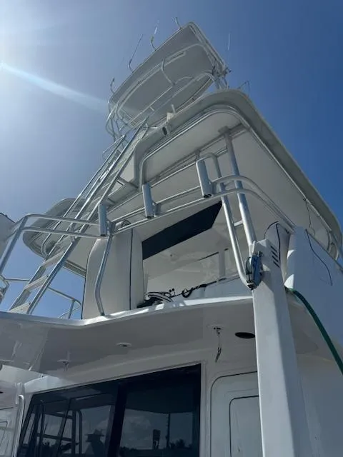 Slide: The Image of 1990 Striker Sportfish boat with tower, viewed from below against a clear blue sky. - 4