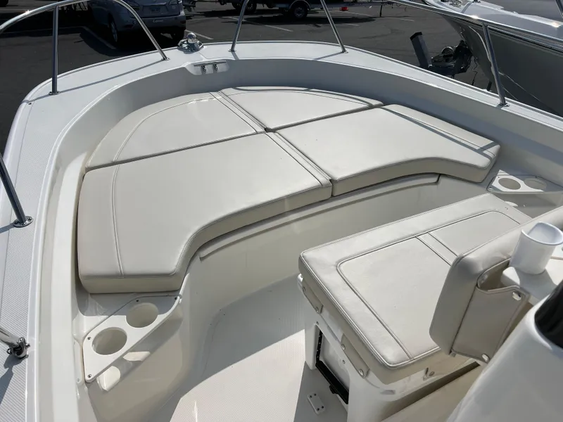 Slide: The Image of 2025 Boston Whaler 190 Montauk boat interior with cushioned seating and cup holders. - 2