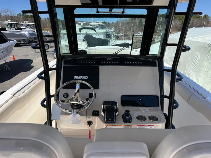 Slide: The Image of 2025 Boston Whaler 330 Outrage helm with Simrad navigation system and modern controls. - 2