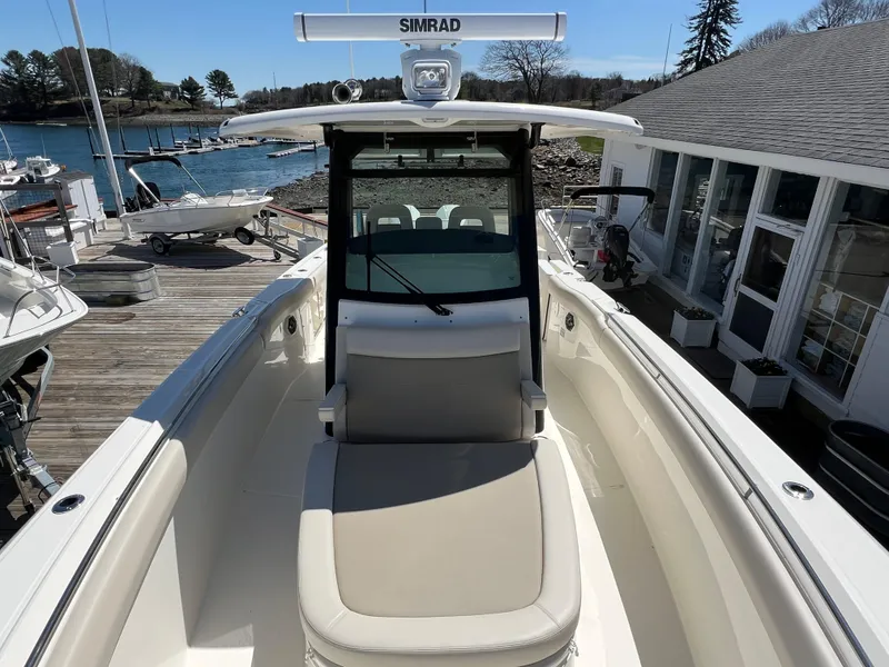 Slide: The Image of 2025 Boston Whaler 330 Outrage boat docked, featuring spacious seating and advanced navigation equipment. - 4