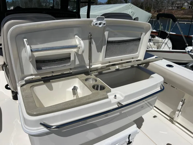 Slide: The Image of 2025 Boston Whaler 330 Outrage boat sink and storage area, featuring modern design and functionality. - 7