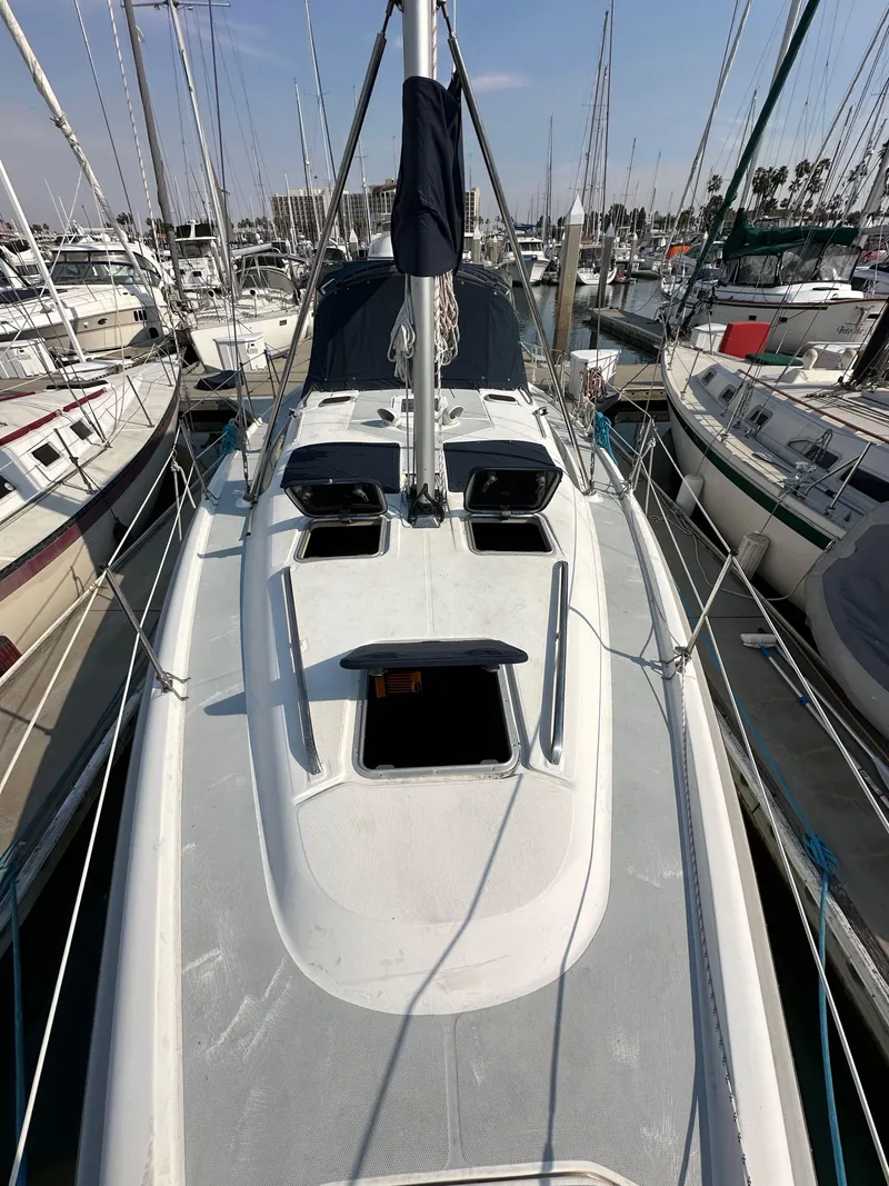 Slide: The Image of 2001 Hunter 380 sailboat docked in marina, surrounded by other boats. - 14