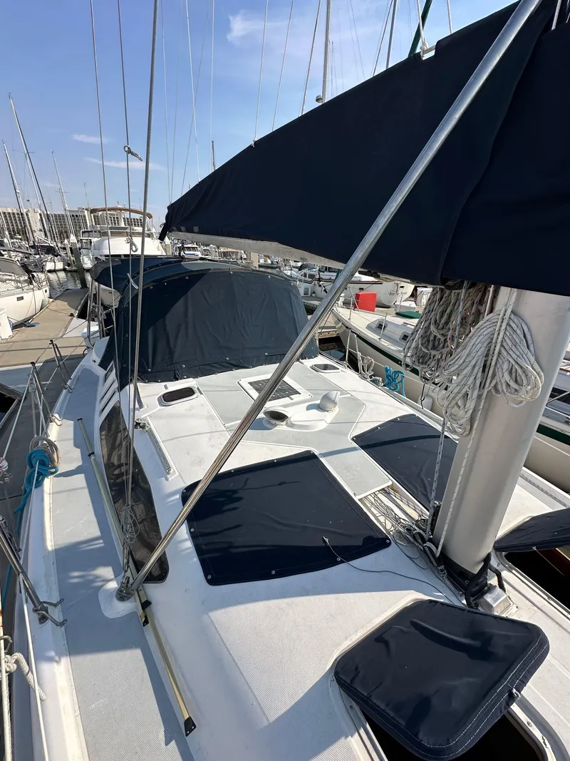 Slide: The Image of 2001 Hunter 380 sailboat docked at marina, featuring sleek design and black sail covers. - 16