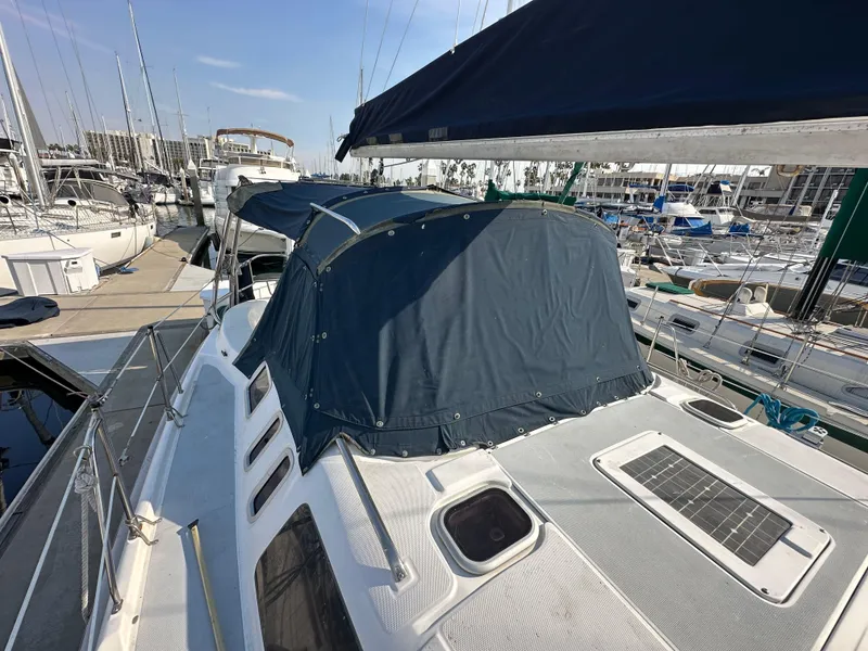 Slide: The Image of 2001 Hunter 380 sailboat docked, featuring a blue canopy and solar panel on deck. - 17