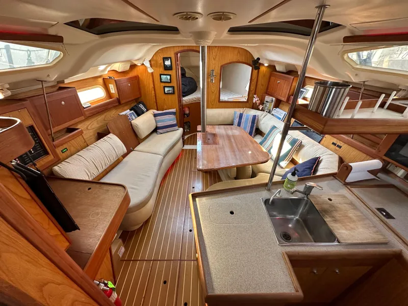 Slide: The Image of Interior of a 2001 Hunter 380 sailboat with cozy seating and wooden finishes. - 23