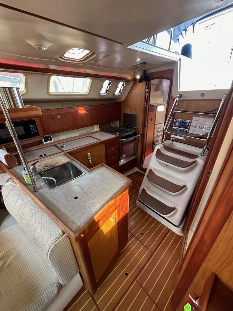 Slide: The Image of Interior of 2001 Hunter 380 sailboat with kitchen and wooden flooring. - 24