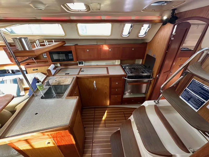 Slide: The Image of Interior of 2001 Hunter 380 sailboat kitchen with wood cabinetry and modern appliances. - 25