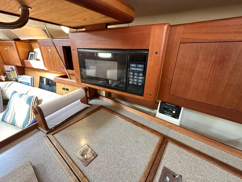 Slide: The Image of Interior of 2001 Hunter 380 sailboat with wooden cabinetry and built-in microwave. - 26