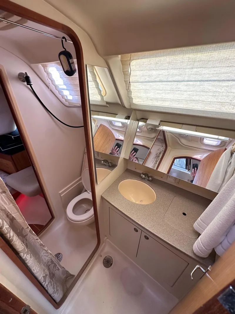 Slide: The Image of Bathroom interior of a 2001 Hunter 380 yacht, featuring a sink, toilet, and shower. - 31