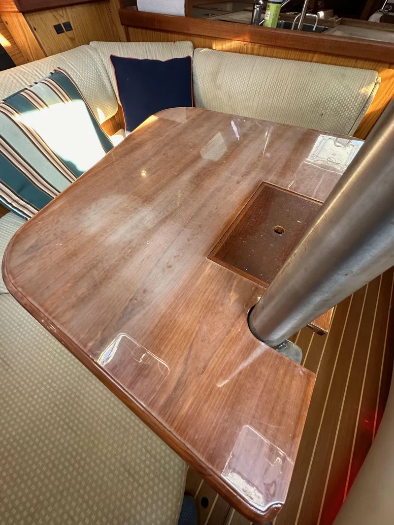 Slide: The Image of Interior of 2001 Hunter 380 sailboat with wooden table and cushioned seating. - 45