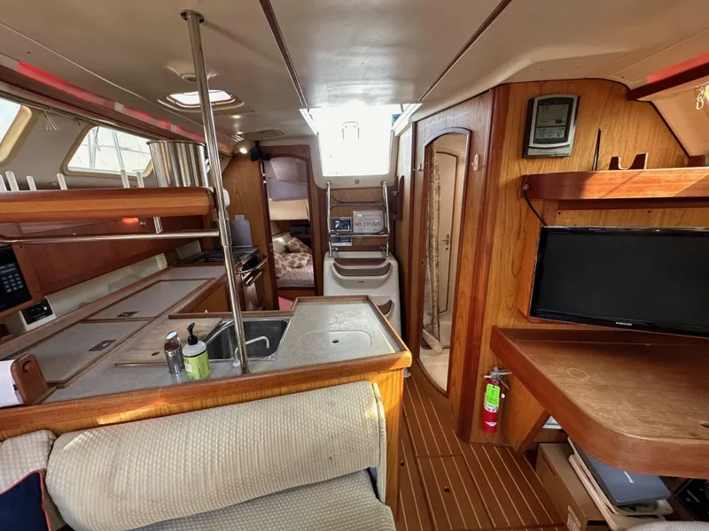 Slide: The Image of Interior of a 2001 Hunter 380 sailboat, featuring a cozy cabin with wood finishes. - 46