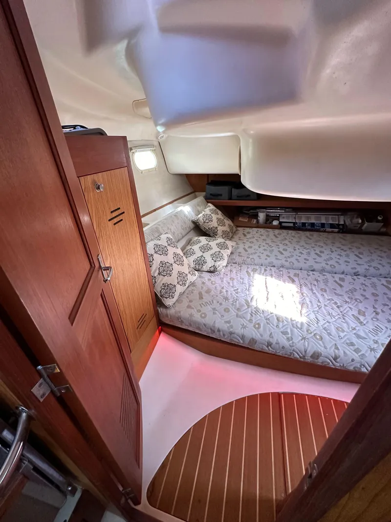 Slide: The Image of Cozy cabin interior of a 2001 Hunter 380 sailboat with wooden accents and bedding. - 47