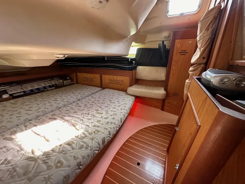 Slide: The Image of Interior of a 2001 Hunter 380 sailboat cabin with bed and wooden cabinetry. - 49