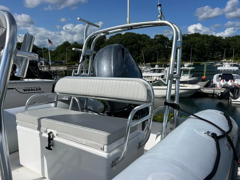 Slide: The Image of 2022 Ribcraft 5.85 boat interior with seating, docked at marina under blue sky. - 9