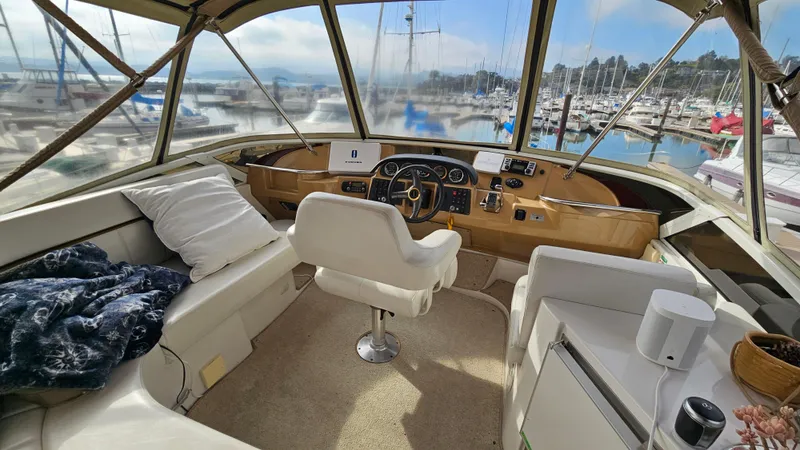 Slide: The Image of 2002 Carver 396 Motor Yacht interior with helm, seating, and marina view. - 3