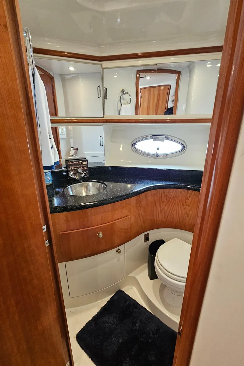 Slide: The Image of 2002 Carver 396 Motor Yacht bathroom with sink, toilet, and wooden cabinetry. - 11