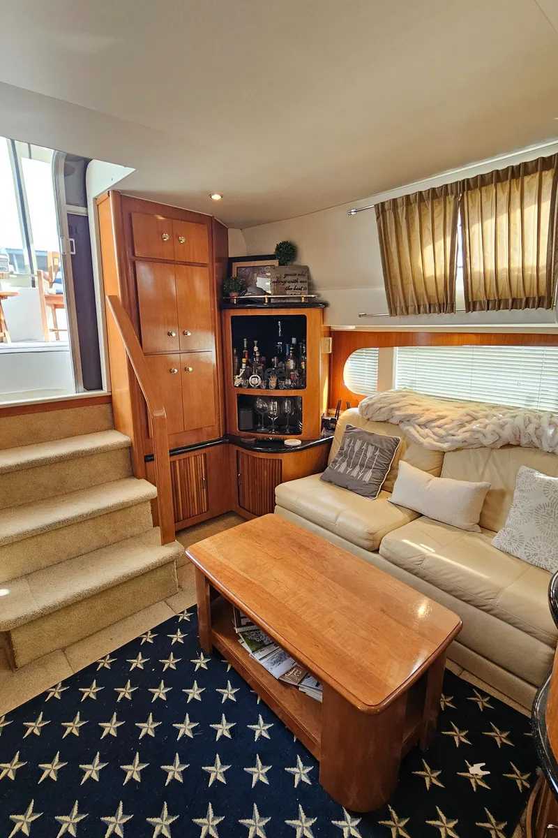 Slide: The Image of Interior of 2002 Carver 396 Motor Yacht with cozy seating and wooden cabinetry. - 15