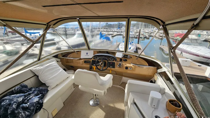 Slide: The Image of Interior view of 2002 Carver 396 Motor Yacht helm with marina background. - 2