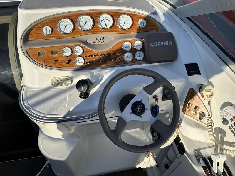 Slide: The Image of Cobalt 293 boat dashboard, 2000 model, featuring gauges, steering wheel, and Garmin device. - 11