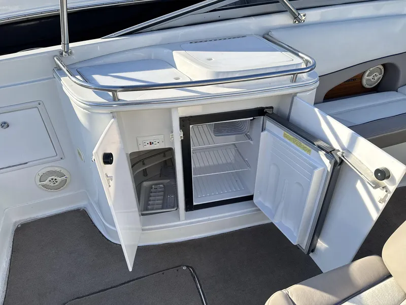 Slide: The Image of Open mini fridge on a 2000 Cobalt 293 boat, showing interior shelves. - 14