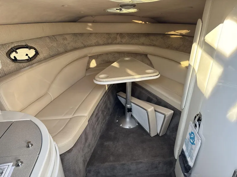 Slide: The Image of Interior of a 2000 Cobalt 293 boat with beige seating and a small table. - 15