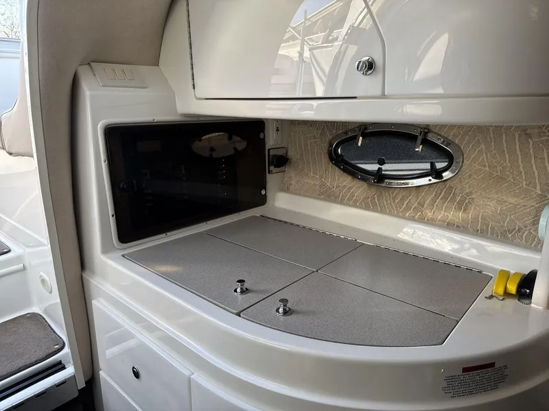 Slide: The Image of Interior of a 2000 Cobalt 293 boat, featuring a compact kitchenette area. - 16