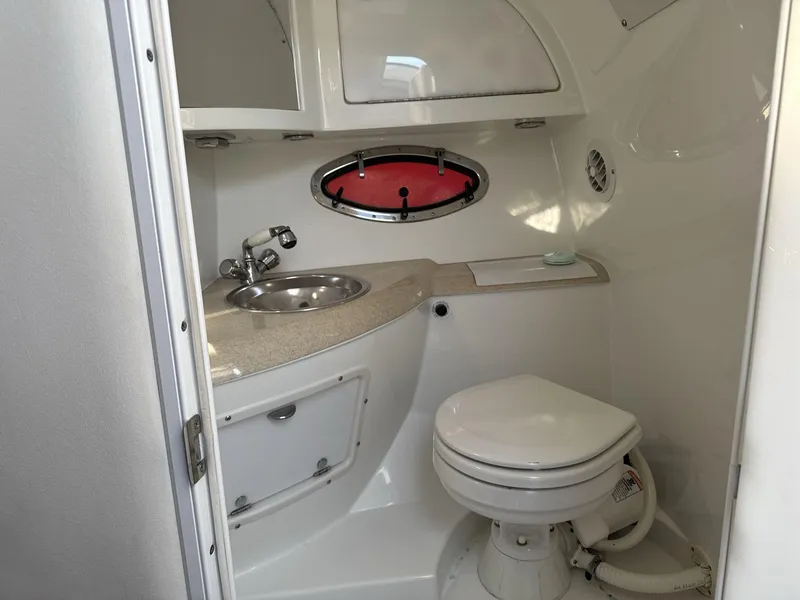 Slide: The Image of Compact bathroom in a 2000 Cobalt 293 boat, featuring a sink and toilet. - 17