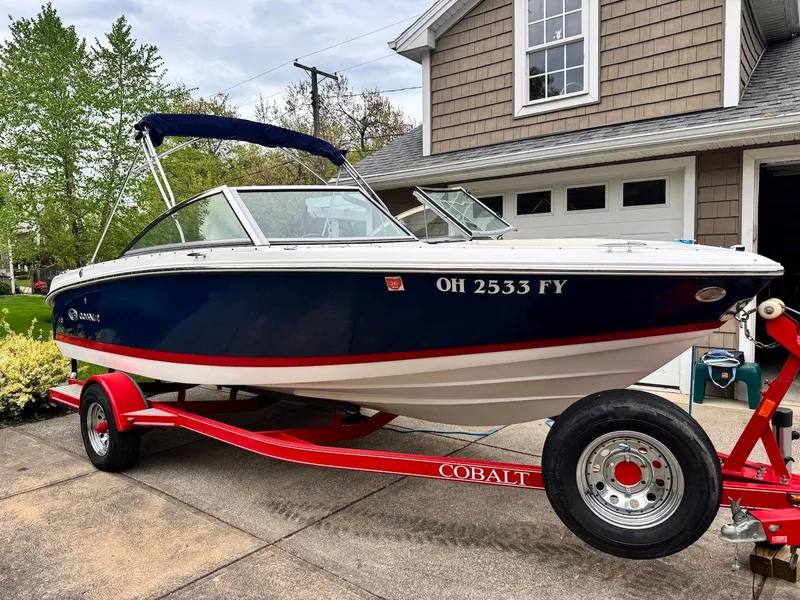 The Image of 2016 Cobalt 200S boat on red trailer parked in driveway. - 0