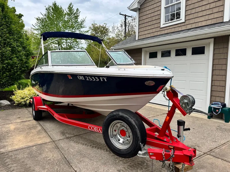 Slide: The Image of 2016 Cobalt 200S boat on red trailer parked in driveway. - 1