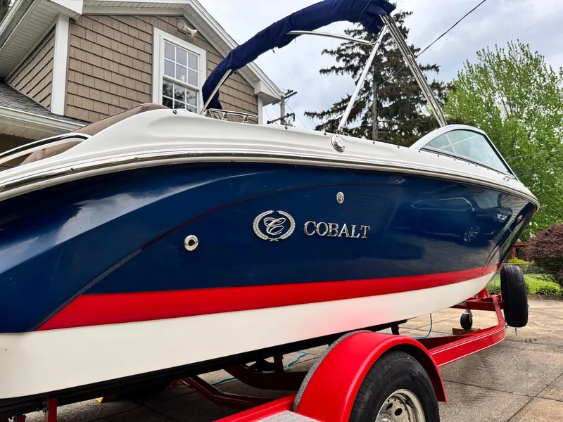 Slide: The Image of 2016 Cobalt 200S boat on red trailer, parked in driveway. - 3