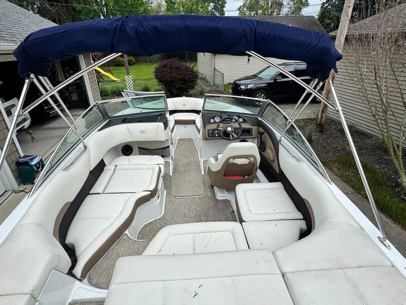 Slide: The Image of 2016 Cobalt 200S boat with white seating and blue canopy in a driveway. - 6