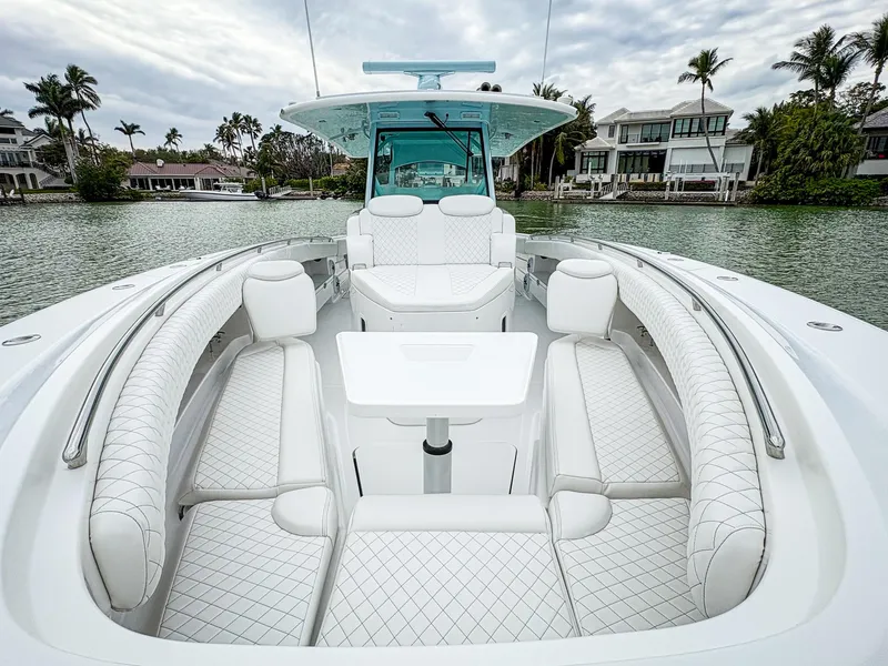 Slide: The Image of 2023 HCB 42 Lujo boat with luxurious seating and table on a scenic waterway. - 19