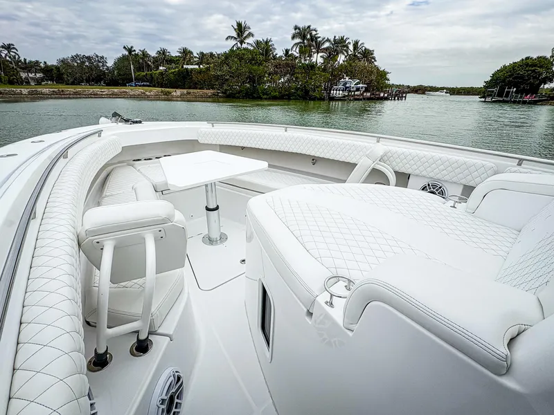 Slide: The Image of 2023 HCB 42 Lujo boat with luxurious seating and table on calm water. - 20