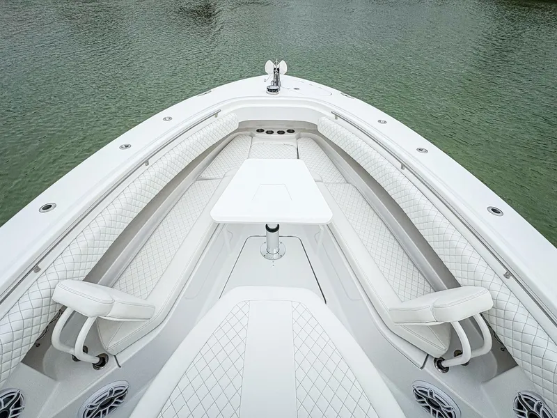 Slide: The Image of 2023 HCB 42 Lujo boat interior with white seating and table on calm water. - 21