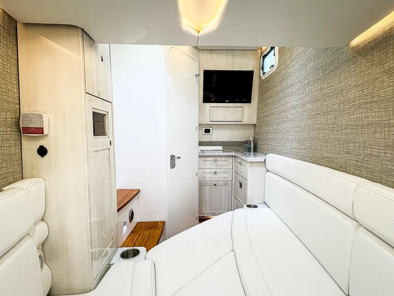 Slide: The Image of 2023 HCB 42 Lujo interior with white seating, cabinetry, and a mounted TV. - 27