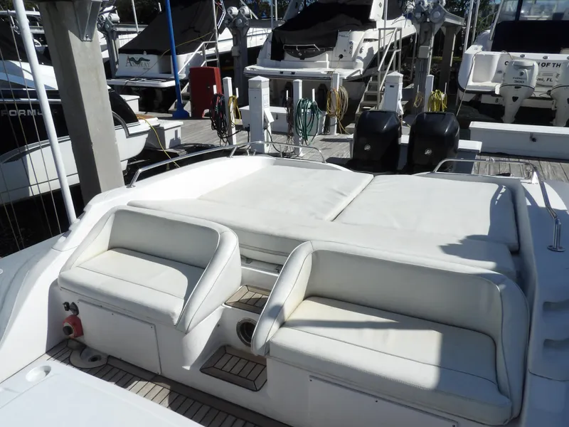 Slide: The Image of 2004 SACS 42 yacht with white seating and sunbed at a marina. - 16