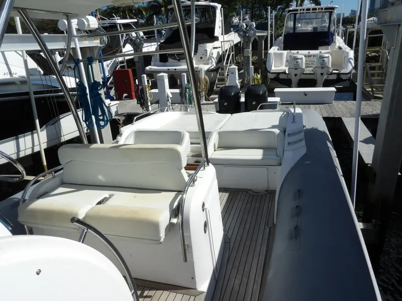 Slide: The Image of 2004 SACS 42 boat with white seating, docked among other vessels. - 22