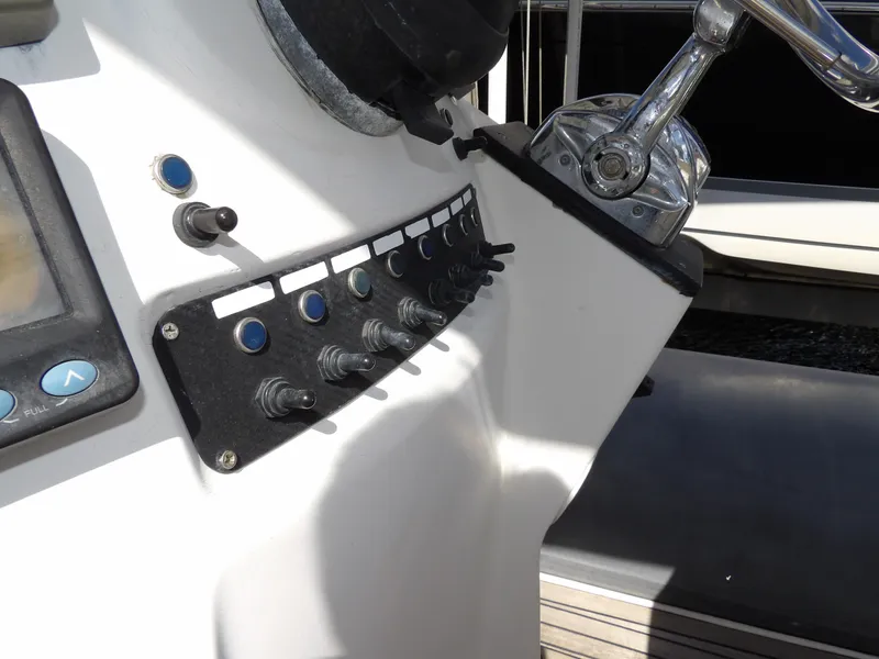 Slide: The Image of Control panel of a 2004 SACS 42 boat with switches and steering wheel. - 30