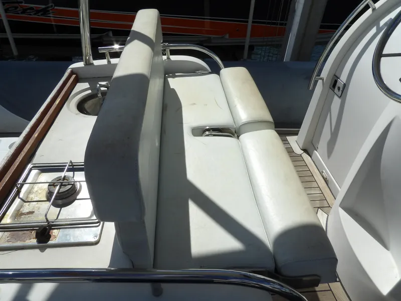 Slide: The Image of 2004 SACS 42 boat interior with white seating and a small stove. - 31