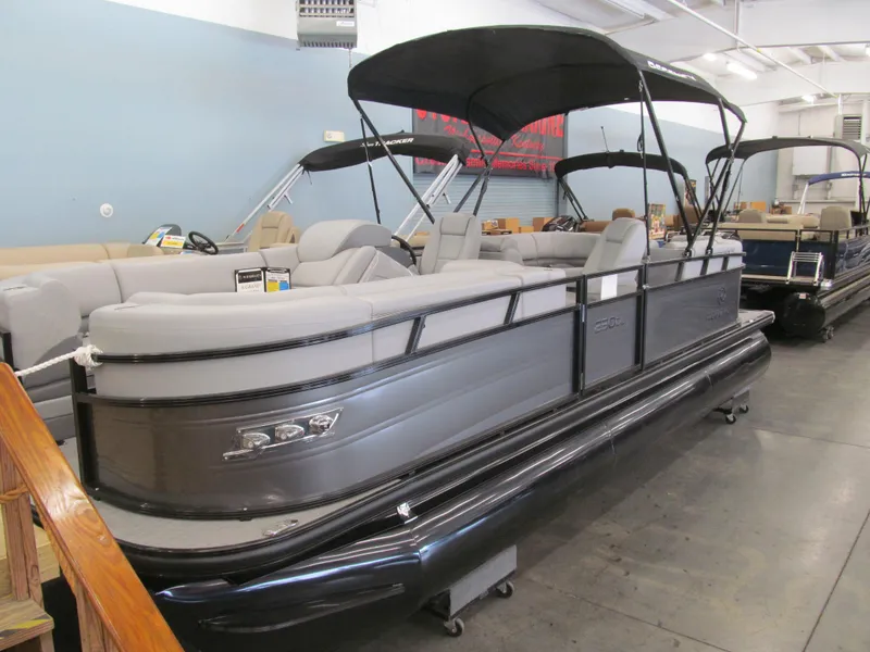 Slide: The Image of 2025 Regency 230 DL3 pontoon boat with canopy in showroom setting. - 0