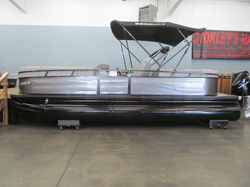 Slide: The Image of 2025 Regency 230 DL3 pontoon boat with canopy in showroom setting. - 1