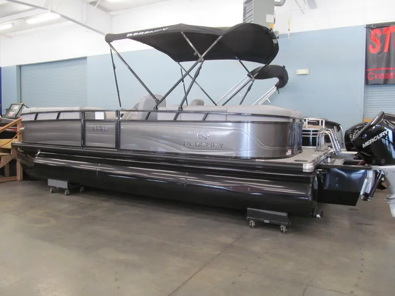 Slide: The Image of 2025 Regency 230 DL3 pontoon boat with canopy, displayed indoors. - 2