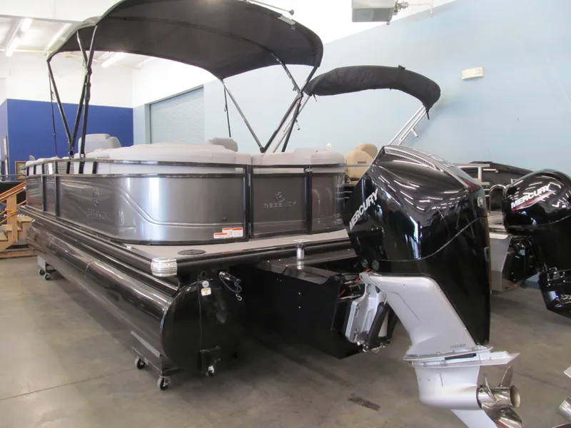 Slide: The Image of 2025 Regency 230 DL3 pontoon boat with Mercury outboard motor in showroom. - 3