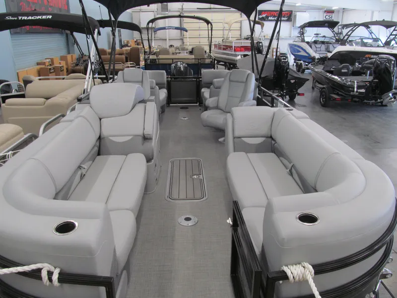 Slide: The Image of 2025 Regency 230 DL3 pontoon boat with spacious seating and modern design in showroom. - 4