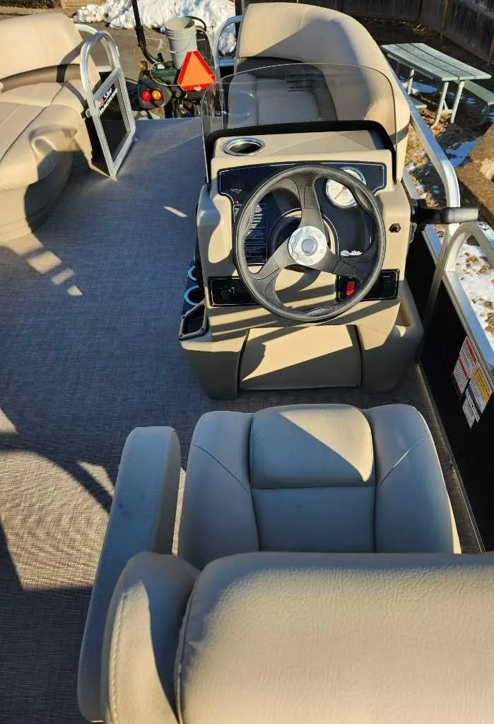 Slide: The Image of 2025 Sun Tracker Party Barge 16 DLX interior with steering wheel and seating. - 3