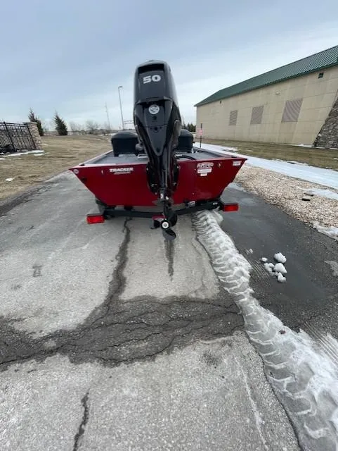 Slide: The Image of 2025 Tracker Bass Tracker Classic XL boat with 50 HP engine on a paved surface. - 2