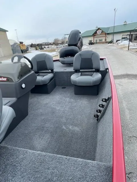 Slide: The Image of 2025 Tracker Bass Tracker Classic XL boat with gray seating and red trim, parked outdoors. - 5