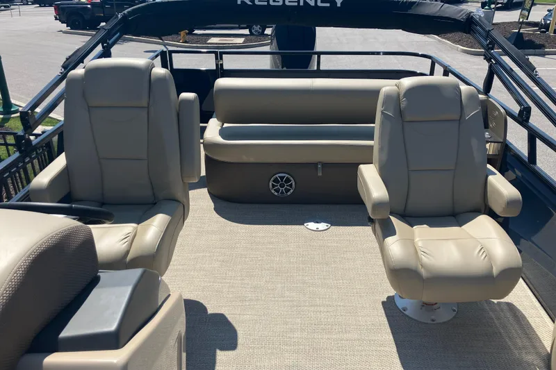 Slide: The Image of 2025 Regency 250 DL3 pontoon boat interior with beige seating and carpet flooring. - 15